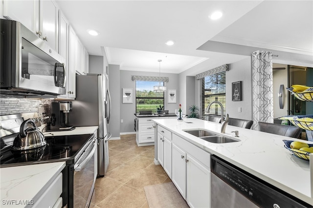 kitchen with backsplash, ornamental molding, stainless steel appliances, white cabinetry, and a sink