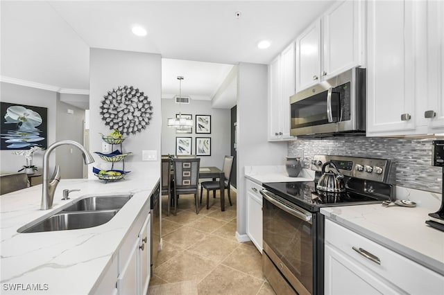 kitchen featuring visible vents, a sink, appliances with stainless steel finishes, crown molding, and backsplash