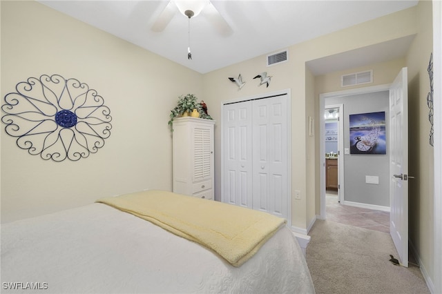 bedroom featuring baseboards, visible vents, a closet, and light carpet