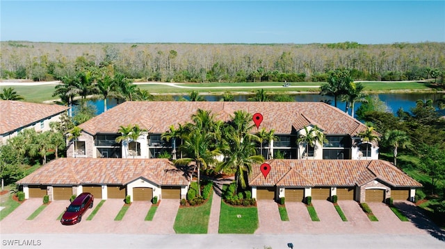 birds eye view of property with a forest view and a water view