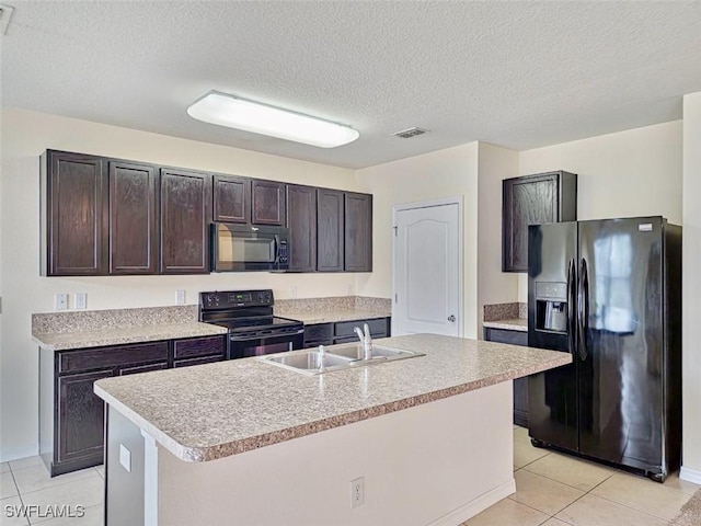 kitchen featuring visible vents, dark brown cabinetry, light countertops, black appliances, and a sink