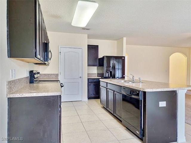 kitchen featuring visible vents, light tile patterned flooring, a sink, black appliances, and light countertops