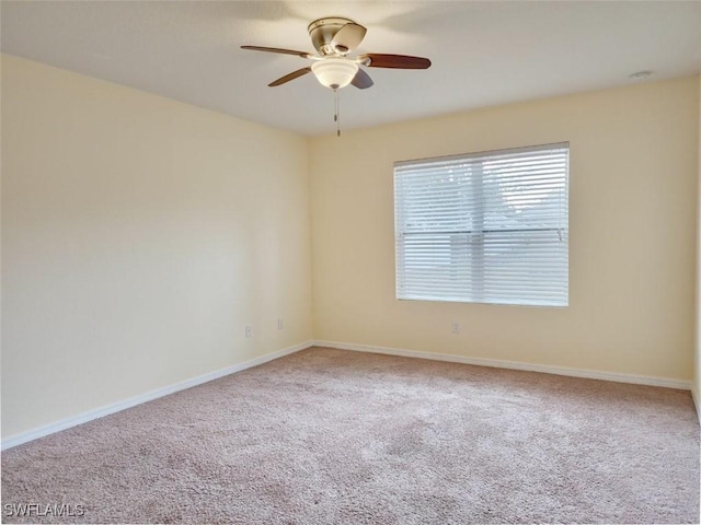 empty room featuring carpet flooring, baseboards, and ceiling fan