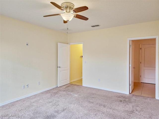 spare room with baseboards, carpet, visible vents, and ceiling fan