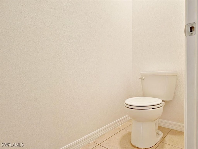 bathroom with tile patterned flooring, toilet, and baseboards