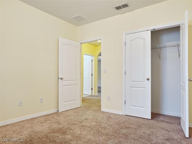 unfurnished bedroom featuring a closet, visible vents, baseboards, and carpet