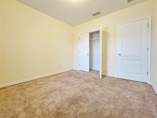 unfurnished bedroom featuring a closet, baseboards, visible vents, and carpet floors