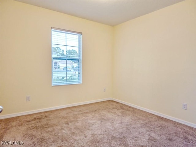 carpeted empty room with baseboards