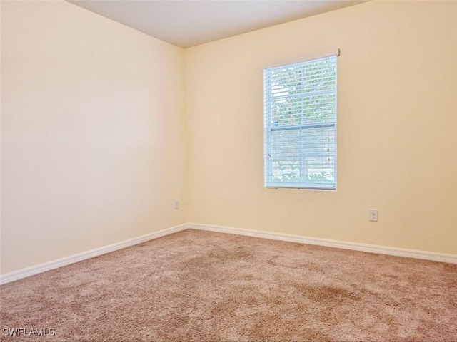 empty room featuring baseboards and carpet floors