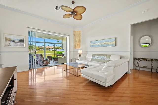 living room featuring ceiling fan, wood finished floors, visible vents, and ornamental molding