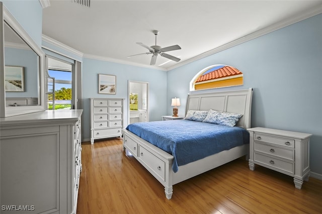 bedroom with visible vents, crown molding, ceiling fan, and wood finished floors