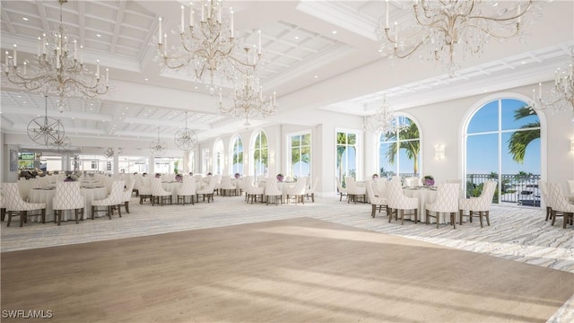 interior space with beamed ceiling, coffered ceiling, wood finished floors, a high ceiling, and a chandelier