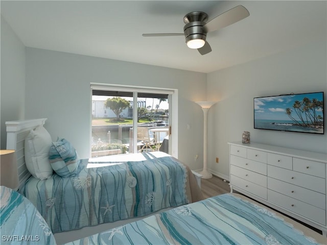 bedroom featuring access to exterior, wood finished floors, baseboards, and ceiling fan