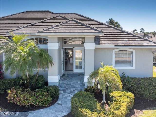 property entrance featuring stucco siding and a tile roof