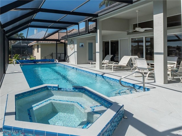 view of swimming pool with a pool with connected hot tub, a lanai, a ceiling fan, and a patio area