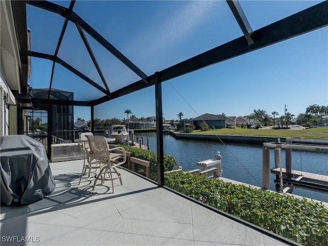 view of patio with a lanai, grilling area, a dock, and a water view