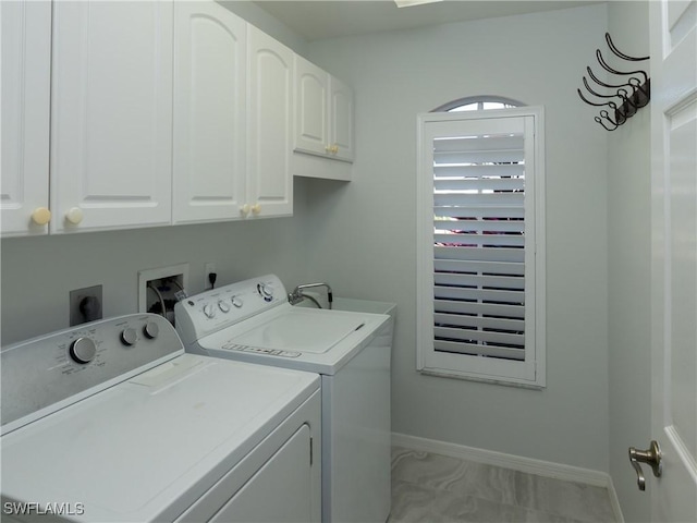 laundry room featuring washer and clothes dryer, cabinet space, and baseboards