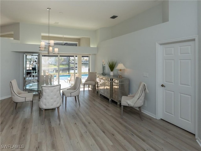 dining space featuring wood finished floors, visible vents, and baseboards