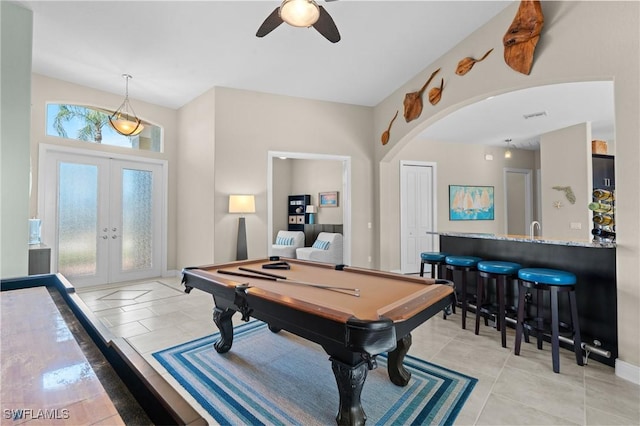 playroom featuring a ceiling fan, french doors, arched walkways, light tile patterned flooring, and pool table