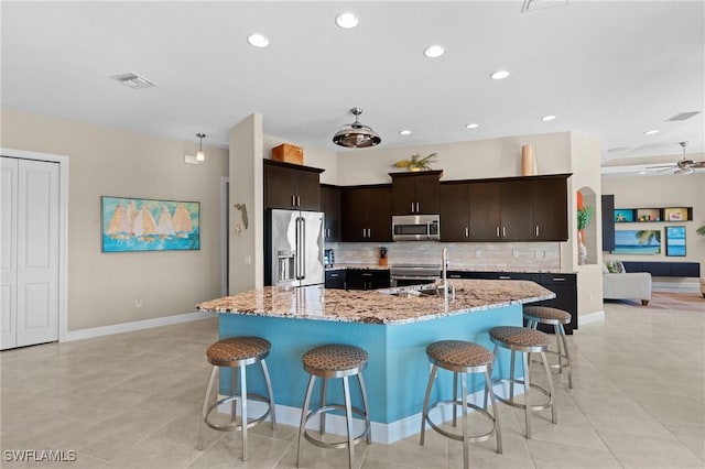 kitchen with a ceiling fan, visible vents, a sink, appliances with stainless steel finishes, and tasteful backsplash