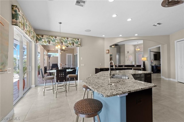 kitchen featuring a chandelier, visible vents, a sink, and a kitchen island with sink