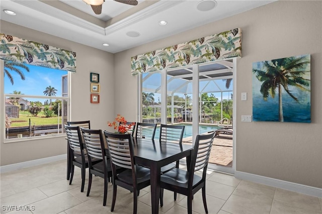 dining space featuring baseboards, a raised ceiling, ceiling fan, and a sunroom