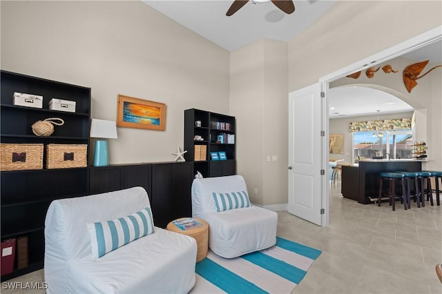 sitting room with tile patterned floors and a ceiling fan