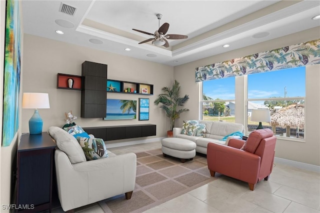 living area featuring visible vents, baseboards, a tray ceiling, recessed lighting, and a ceiling fan