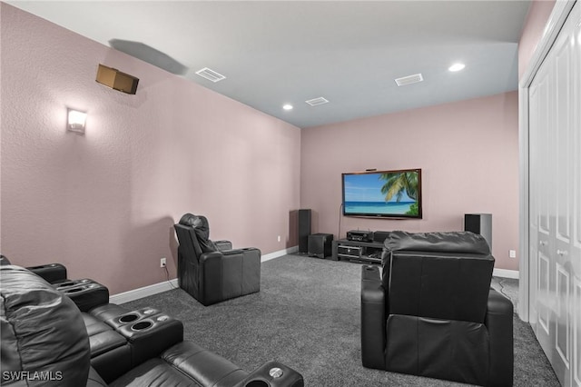 cinema room with carpet, visible vents, and baseboards