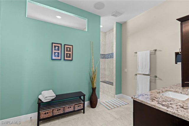 full bathroom featuring visible vents, baseboards, vanity, and a tile shower