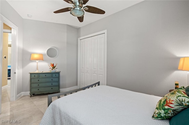 bedroom with light tile patterned flooring, baseboards, a closet, and ceiling fan