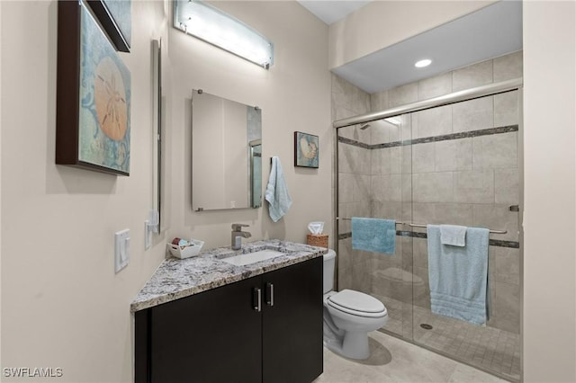 bathroom featuring vanity, tile patterned floors, toilet, and a stall shower