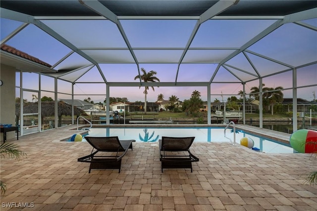 pool with glass enclosure and a patio