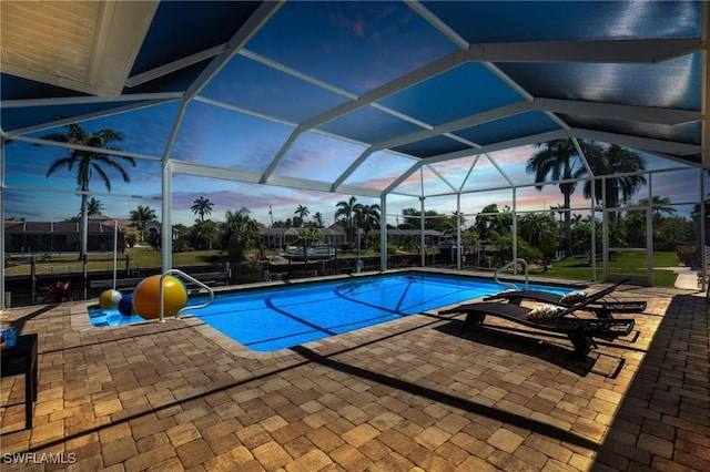 pool featuring glass enclosure and a patio area