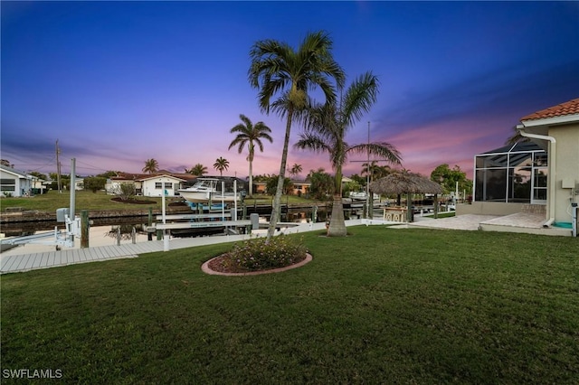 view of yard featuring a gazebo, boat lift, and a boat dock