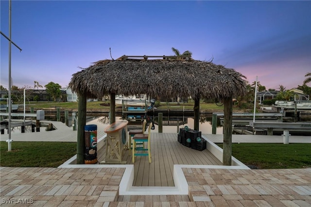 view of home's community featuring a yard, a dock, a water view, and boat lift