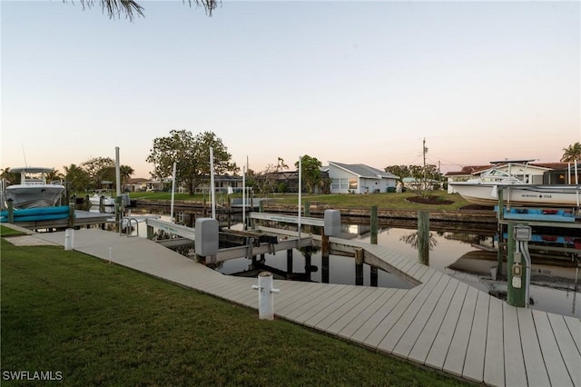 view of dock featuring boat lift, a yard, and a water view