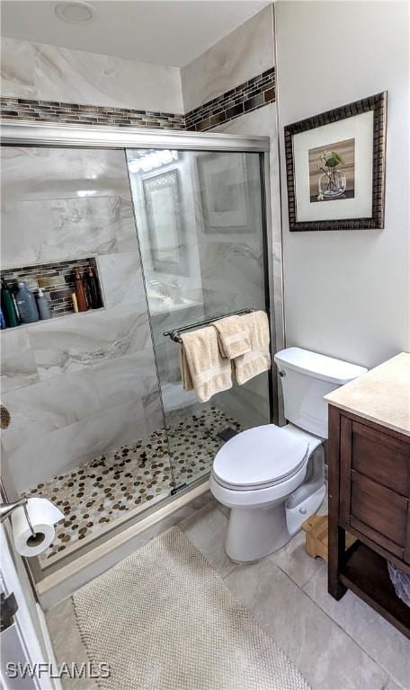 bathroom with a shower stall, toilet, and vanity