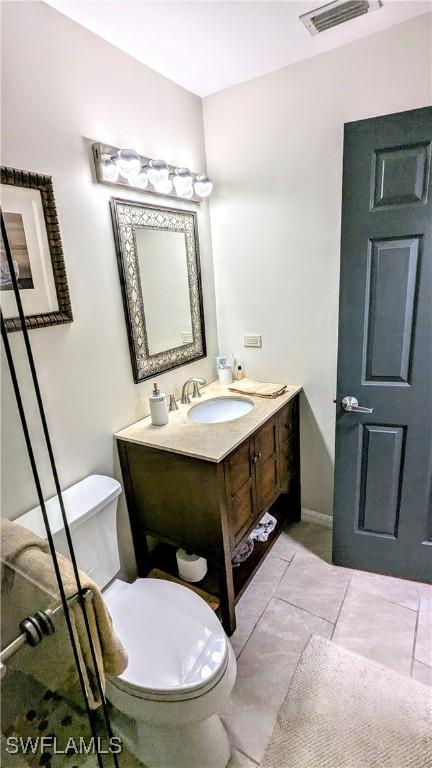 bathroom featuring visible vents, toilet, tile patterned flooring, and vanity