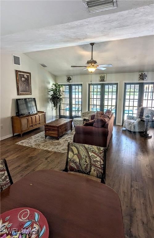 living room featuring visible vents, hardwood / wood-style flooring, and french doors