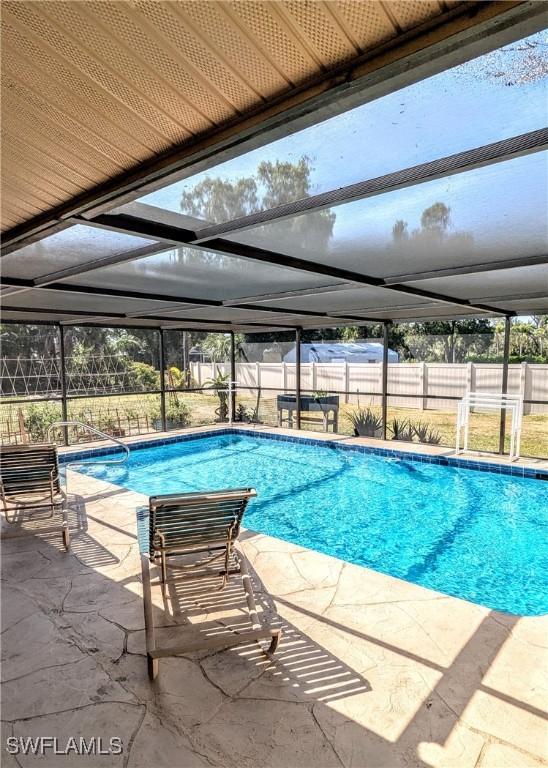 view of swimming pool featuring a fenced in pool, a patio area, glass enclosure, and a fenced backyard