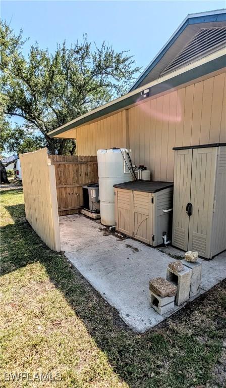view of side of home featuring fence and a yard