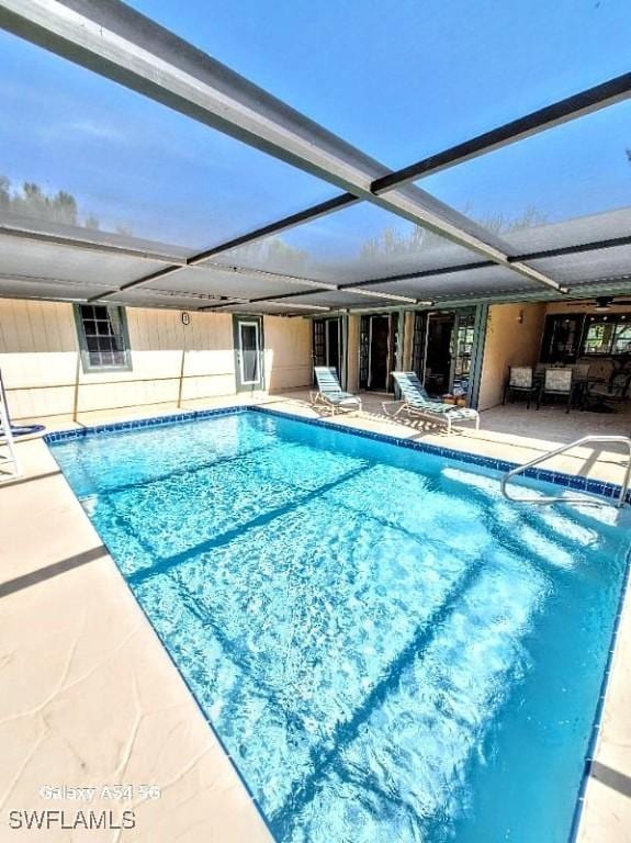 outdoor pool with a lanai and a patio area