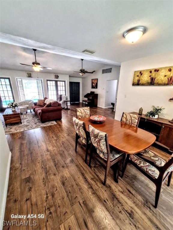 dining space featuring visible vents, ceiling fan, and dark wood finished floors