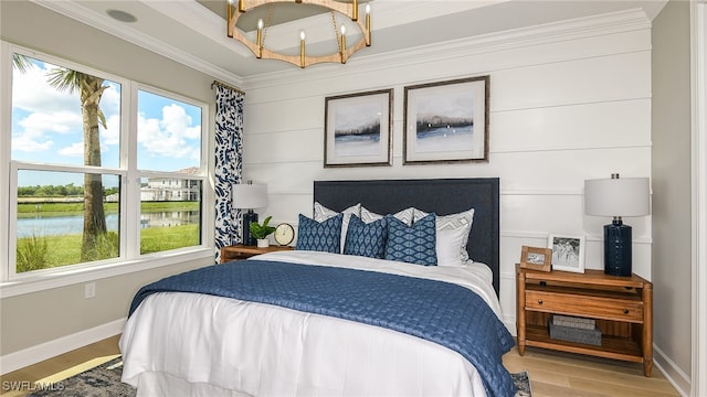 bedroom featuring multiple windows, wood finished floors, a water view, and ornamental molding