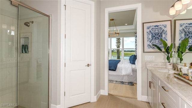 ensuite bathroom with vanity, baseboards, a stall shower, ornamental molding, and connected bathroom