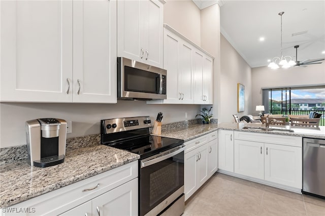 kitchen with ornamental molding, white cabinets, stainless steel appliances, and a sink