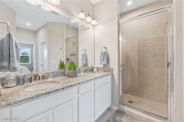 bathroom featuring a sink, visible vents, a stall shower, and double vanity