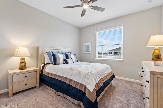 bedroom featuring light carpet, ceiling fan, and baseboards