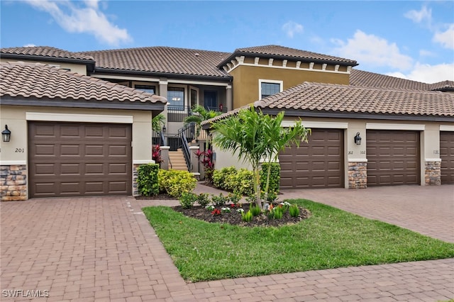 mediterranean / spanish house with decorative driveway and stucco siding